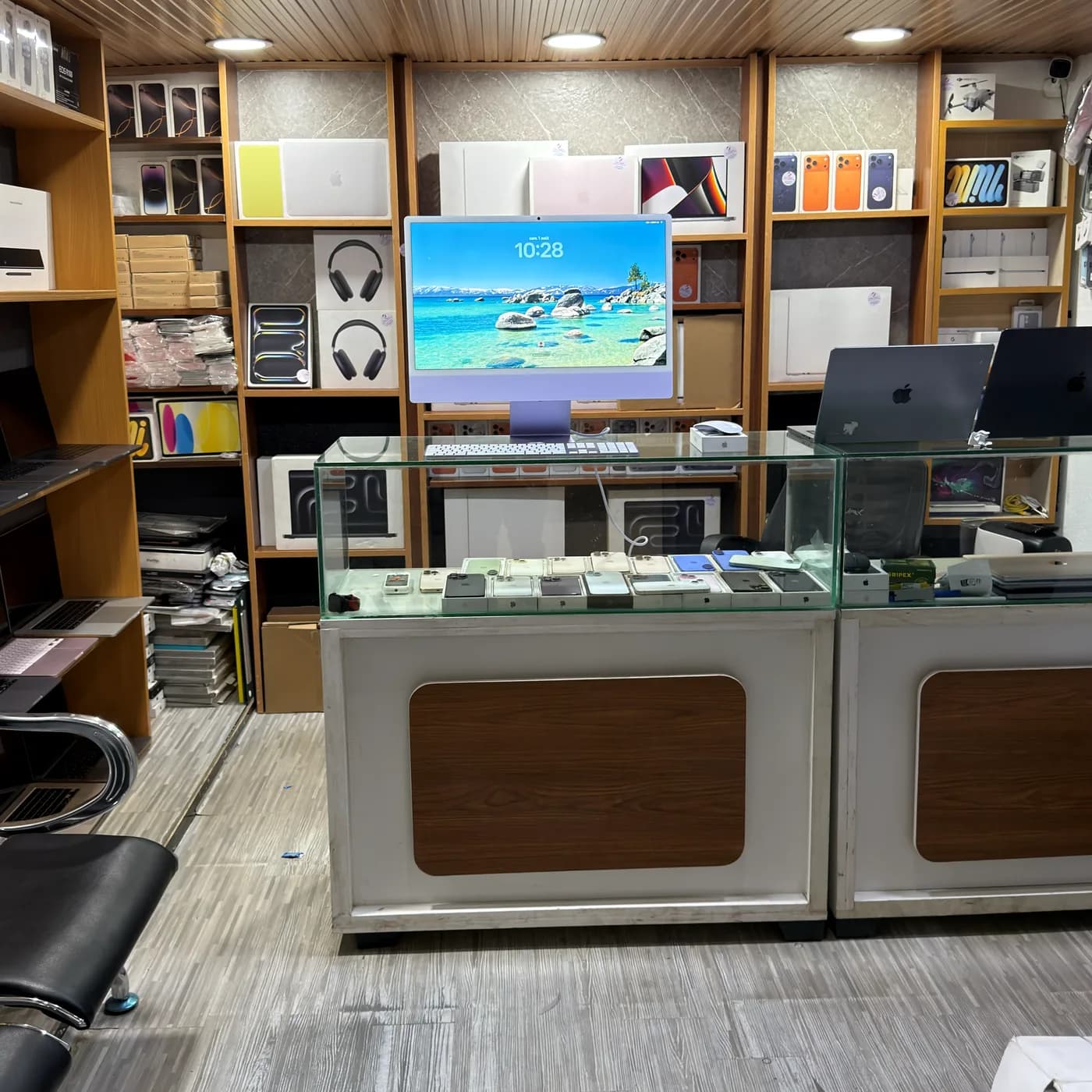 Rayonnages et vitrine de la boutique MacBookShoping : iMac, MacBook, AirPods et iPhone en présentation.